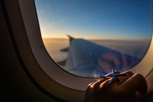 Photo cropped image of hand on window in airplane