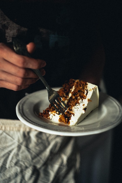 Foto immagine ritagliata di una mano con la torta nel piatto