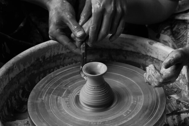 Cropped image of hands making pot at workshop