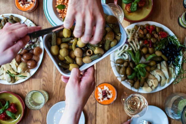 Photo cropped image of hands with food served on table