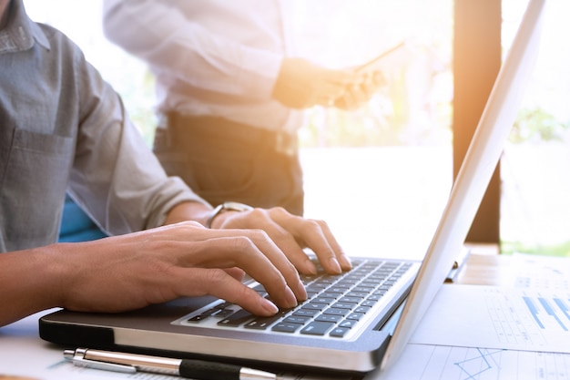 Cropped image of handsome businessmen using laptop at a office