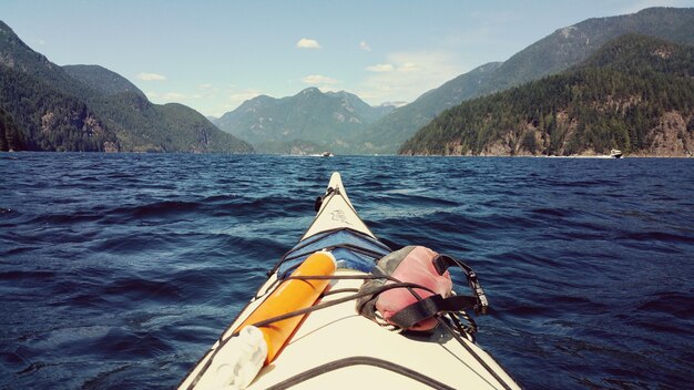 Foto immagine ritagliata di un kayak in mare contro le montagne