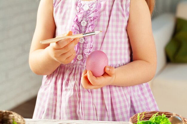 Cropped image of a little girl painting eggs for Easter