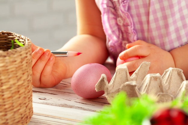 Cropped image of a little girl painting eggs for Easter