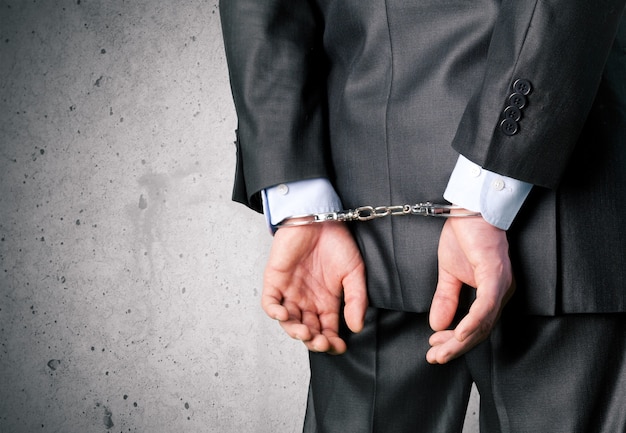 Cropped image of male hands in handcuffs behind his back