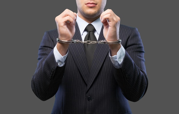 Cropped image of male hands in handcuffs behind his back