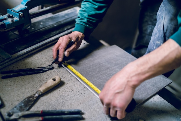 cropped image of male worker measuring wood at table