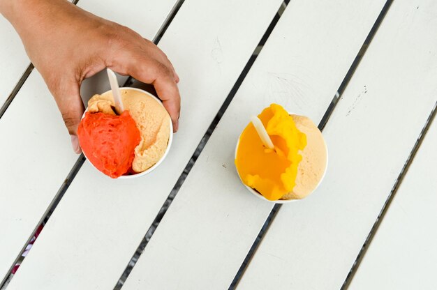 Foto immagine ritagliata di un uomo con la mano che tiene il gelato sul tavolo