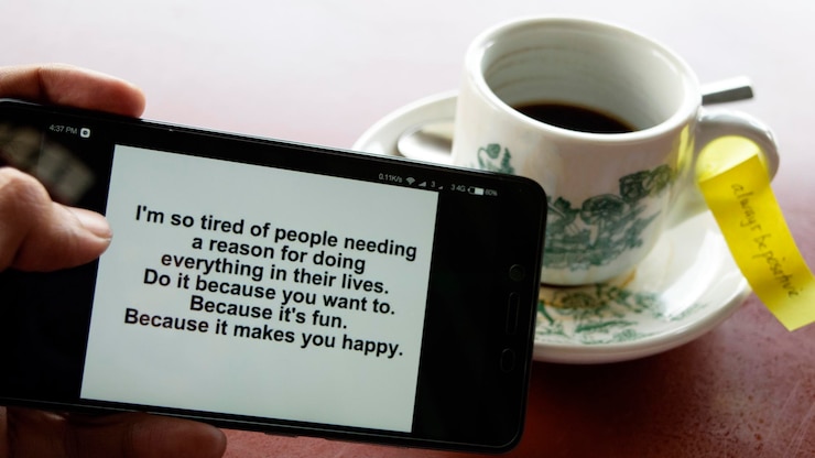 Photo cropped image of man holding phone with message by tea