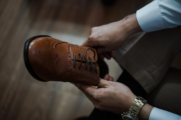 Photo cropped image of man holding a shoe