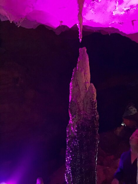 Photo cropped image of man looking at massive icicle