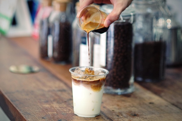 Cropped image of man making iced coffee on table