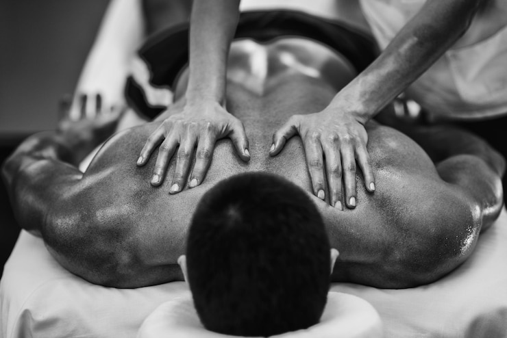 Photo cropped image of man massaging male customer at spa