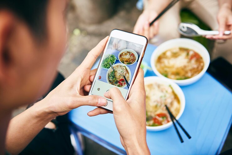 Photo 食べ物を写真に撮っている男性のカットされた画像