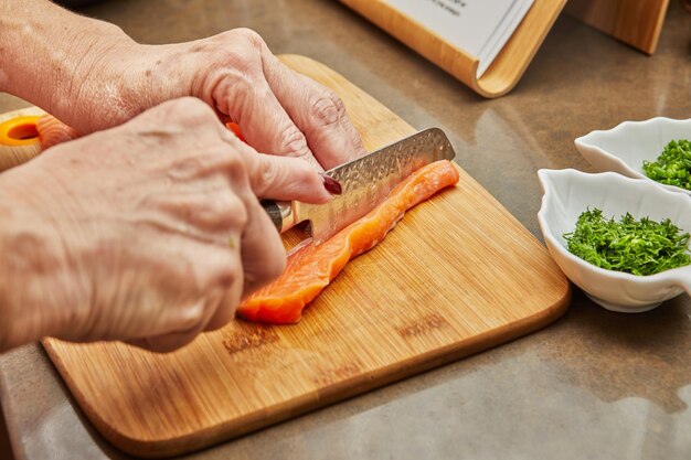 カッティングボードで食べ物を調理している男性のカットされた画像