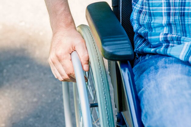 Photo cropped image of man sitting on wheelchair at park