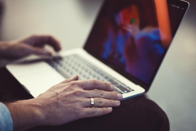 Cropped image of man using laptop at table