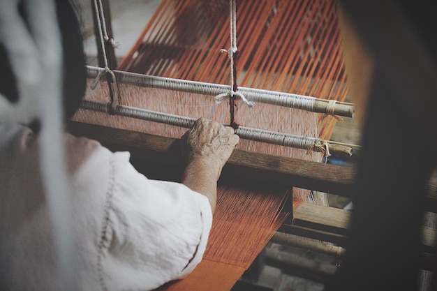 cropped image of man using loom in textile industry