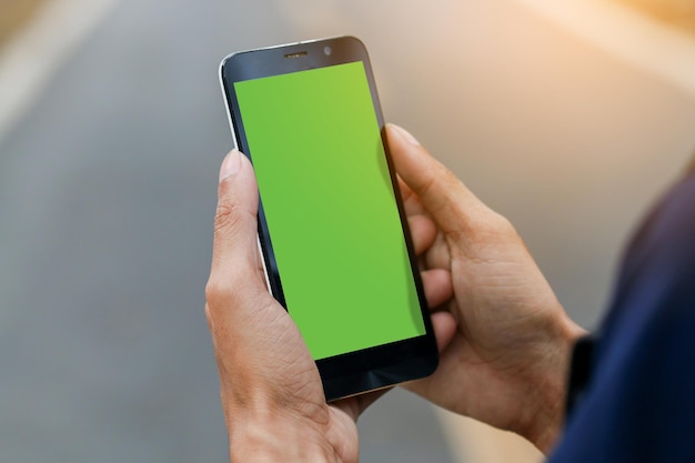 cropped image of man using mobile phone outdoors