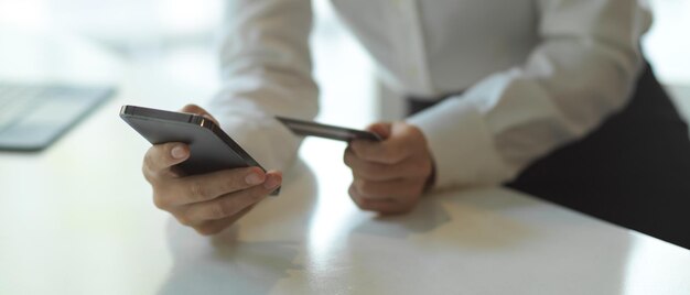 Cropped image of man using mobile phone on table