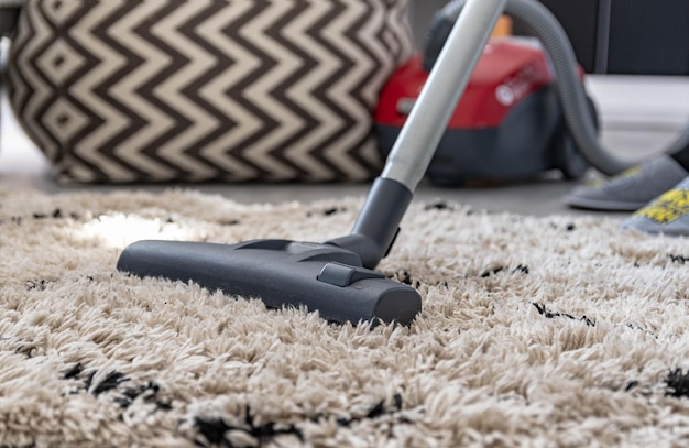 Photo cropped image of man vacuuming carpet