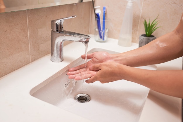 Immagine ritagliata dell'uomo che si lava le mani nel bagno di casa