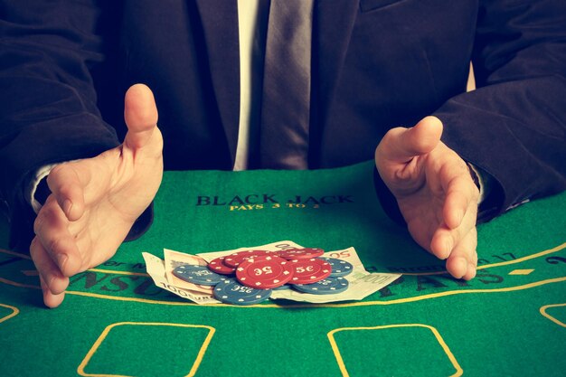 Photo cropped image of man with gambling chips on table