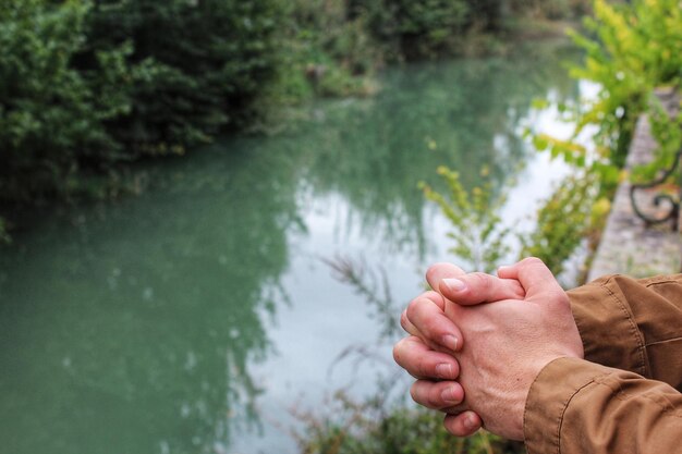 Foto immagine tagliata di un uomo con le mani abbracciate dal lago