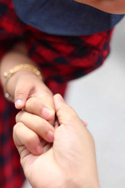 Cropped image of mother holding daughter hand