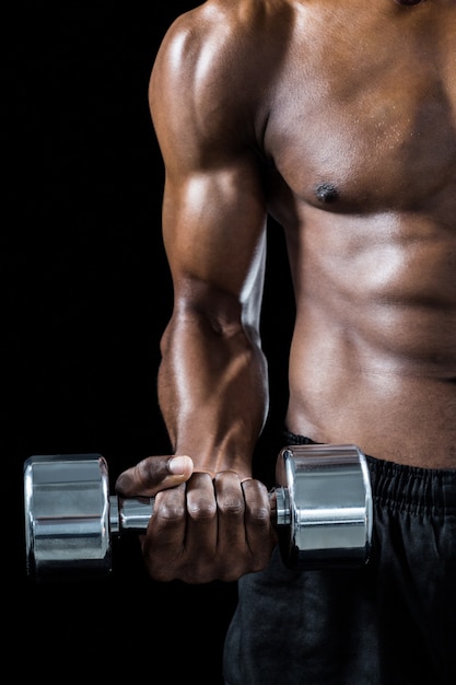 Foto immagine potata dell'uomo muscolare che si esercita con il dumbbell