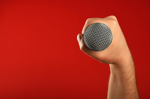 Photo cropped image of musician holding microphone against red background