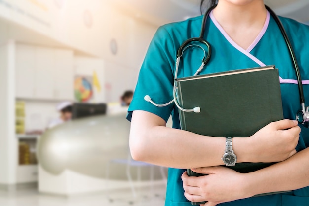 Cropped image of nurse holding green book on white background