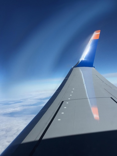 写真 雲の空を背景に航空機の翼をカットした画像