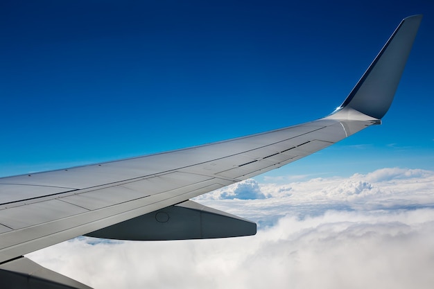 写真 空を飛ぶ航空機の翼のクロップされた画像