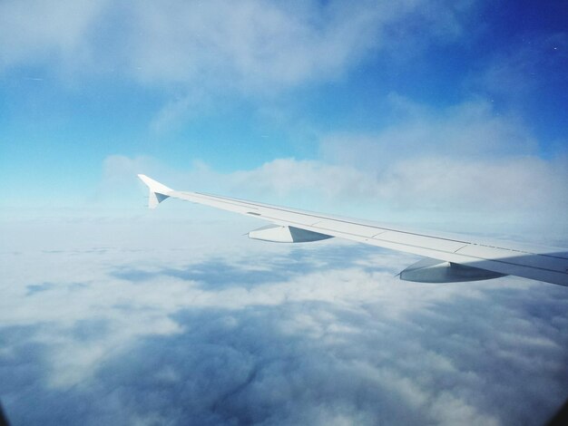 写真 雲の空を飛ぶ飛行機のクロップされた画像