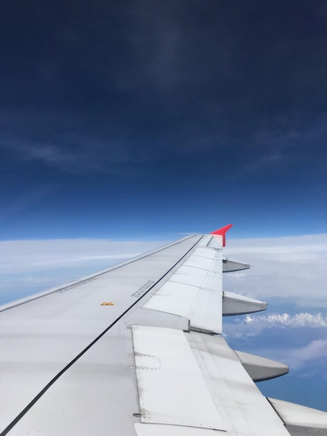 写真 青い空に向かって飛ぶ飛行機のクロップされた画像