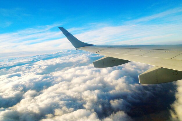 写真 雲の上を飛ぶ飛行機のクロップされた画像