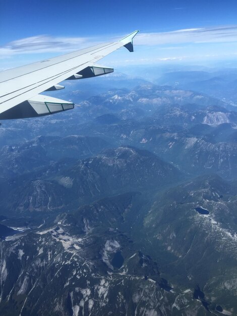 写真 空に向かって山の上を飛ぶ飛行機のクロップされた画像