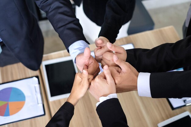 Фото Обрезанное изображение бизнесменов, поднимающих большой палец в офисе