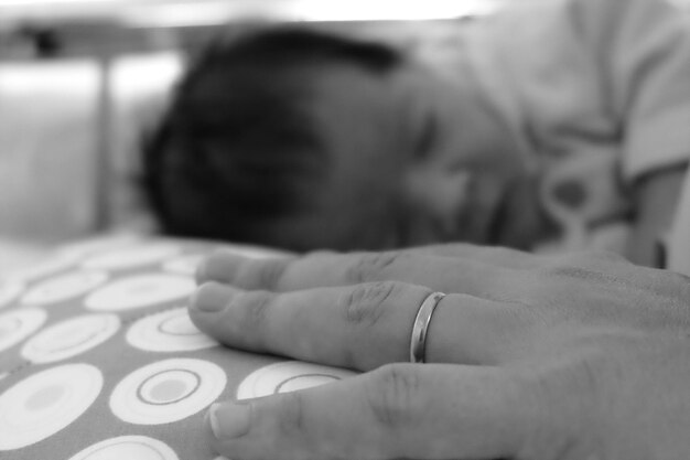 사진 침대에 잠자는 아기 소녀의 손의 절단된 이미지