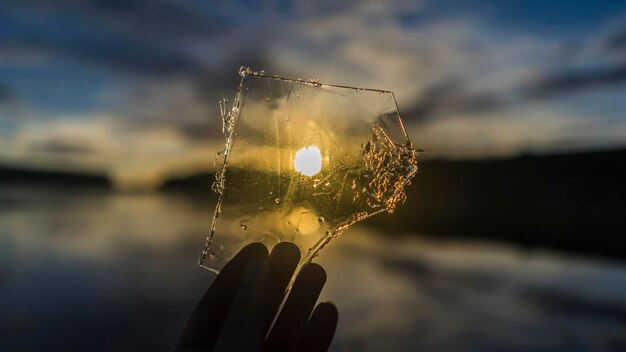 写真 空に向かって氷を握っている手のカットされた画像