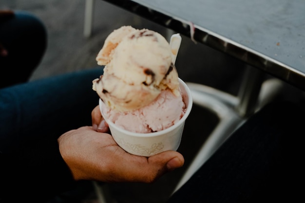 写真 アイスクリームを握っている手のカットされた画像