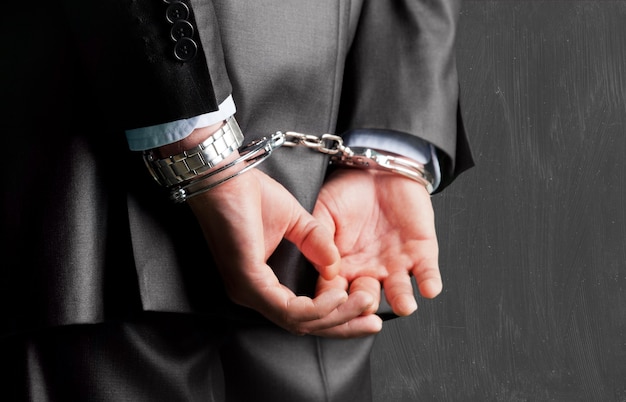 Фото Обрезанное изображение мужских рук в наручниках за спиной