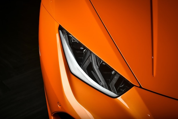 Фото Обрезанное изображение оранжевой машины на черном фоне