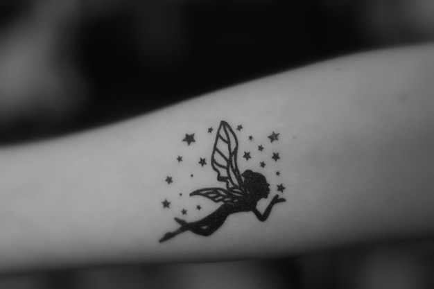 Фото Обрезанное изображение женской руки с татуировкой феи
