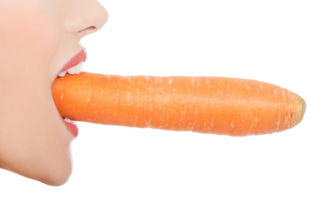 Фото Обрезка изображения молодой женщины, едущей морковь на белом фоне