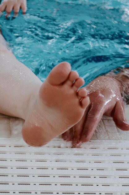 Cropped image of people at swimming pool