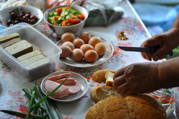 Cropped image of person making sandwich at home