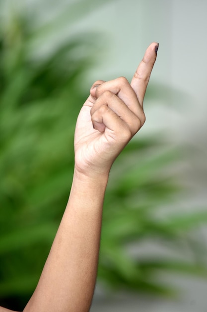 Photo cropped image of person pointing finger up outdoors