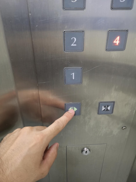 Foto immagine ritagliata di una persona che preme il pulsante dell'ascensore